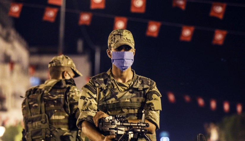 صورة لبعض الجنود يقفون بجانب بعضهم البعض في تونس العاصمة بعد أن أقال الرئيس التونسي قيس سعيد الحكومة وجمّد أعمال البرلمان هذا الأسبوع.