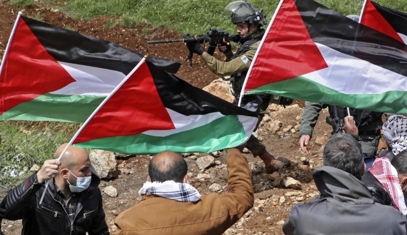 فلسطينيون يتظاهرون قرب نابلس بينما يوجه الجندي الإسرائيلي بندقيته نحوهم