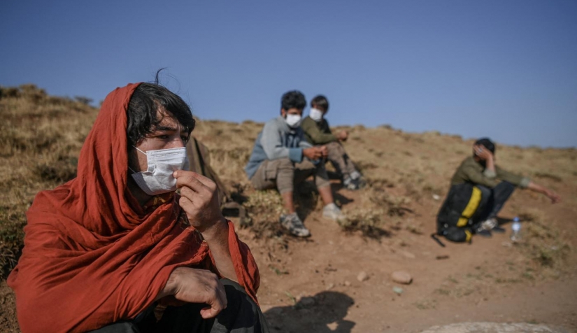مهاجرون أفغان يستريحون أثناء انتظار المهربين بعد عبور الحدود الإيرانية التركية في منطقة تافان، شرق تركيا، في 15 آب/ أغسطس 2021.