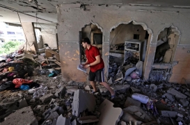 فلسطيني يبحث عن متعلقاته وسط أنقاض منزله الذي دمرته الضربات الجوية الإسرائيلية على غزة