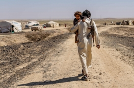 أب نازح يحمل ابنه ويسير نحو خيمتهم المؤقتة في ضواحي مأرب وسط اليمن