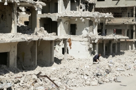 رجل يجمع الحطب بين أنقاض المباني المتضررة في حمص في الثالث من تشرين الأول/ أكتوبر.