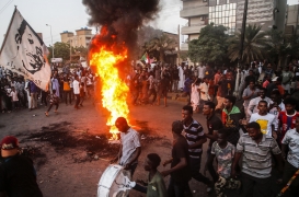 محتجون سودانيون يرددون الهتافات وسط الإطارات المحروقة خلال مظاهرة في العاصمة الخرطوم في 26 تشرين الأول/ أكتوبر.