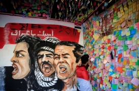 متظاهر عراقي يفف أمام حائط الأمنيات على جدران المطعم التركي في بغداد في أثناء المظاهرات المناهضة للحكومة