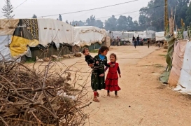 أطفال يسيرون وسط الخيام في مخيم مؤقت للاجئين السوريين في لبنان.