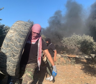 رجال فلسطينيون يستخدمون الإطارات المشتعلة للاحتجاج ضد الاستيطان غير القانوني في بيتا