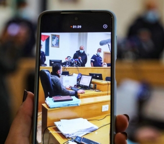 سيدة تستخدم هاتفها في قاعة المحكمة بنابلس في الضفة الغربية