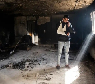 فلسطيني يقف وسط بقايا منزله الذي أحرقه المستوطنون في بلدة حوارة قرب نابلس