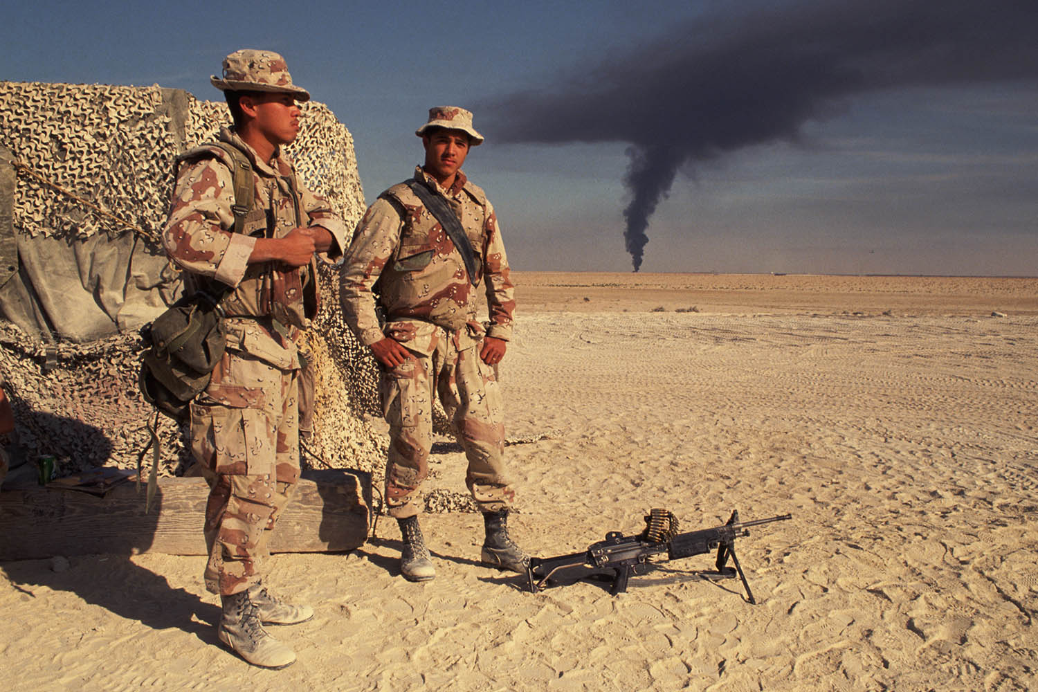  صورة لجنود المارينز الأمريكيين وهم يشاهدون دخانًا أسود  يتصاعد من حريق يندلع من إحدى المنشآت النفطية بعد هجوم العراق على حقول النفط الكويتية خلال شهر كانون الثاني/يناير 1991.
