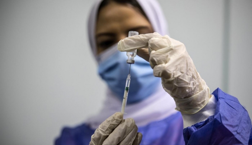 إحدى العاملات في مجال الصحة تجهز جرعة من لقاح أوكسفورد "إسترازينيكا" في 4 مارس/ آذار أول يوم للتطعيم العام في مصر.