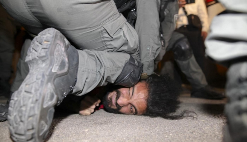 صورة لقوات الأمن الإسرائيلية وهي تعتقل رجلا فلسطينيا أثناء عمليات الإخلاء التي شهدتها العائلات القاطنة في حي الشيخ جراح في الرابع من أيار/مايو سنة 2021.