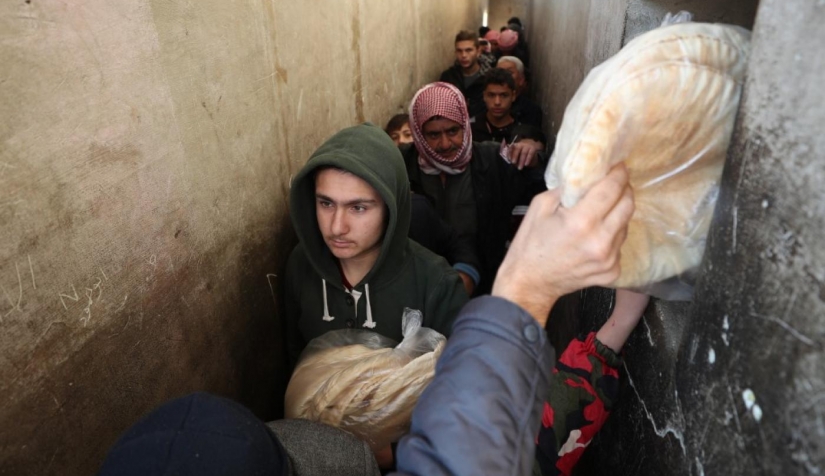 السوريون يقفون في طابور لشراء الخبز في مدينة بنش بمحافظة إدلب شمال غرب سوريا