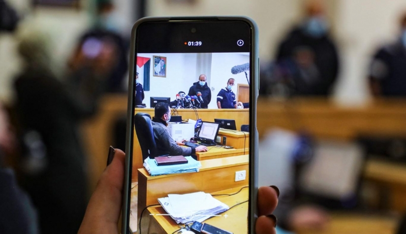 سيدة تستخدم هاتفها في قاعة المحكمة بنابلس في الضفة الغربية