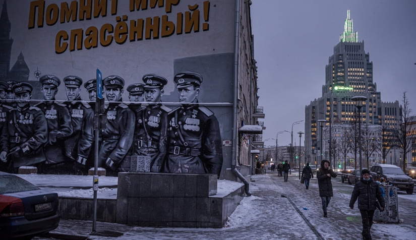 لوحة جدارية تظهر طيارين سوفييت خلال الحرب العالمية الثانية، استنادا إلى صورة من موكب النصر سنة 1945. وتقول اللافتة باللغة الروسية "العالم الذي أنقذتموه يتذكركم".