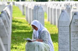 سيدة بوسنية مسلمة تقرأ القرآن بين القبور لأقاربها الذين سقطوا ضحايا مذبحة سربرنيتسا