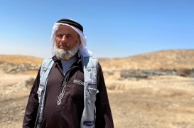 يقف علي جبارين في قرية جنبا إحدى قرى مسافر يطا التي تواجه تهجيرًا إسرائيليًا وشيكًا