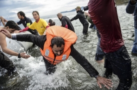 اللاجئون يترجلون من القارب عند جزيرة ليسبوس اليونانية بعد عبورهم بحر إيجة من تركيا