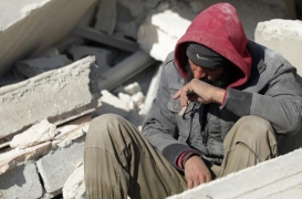 رجل يجلس بجوار الأنقاض منتظرًا أي أخبار عن أسرته العالقة تحت الأنقاض في سوريا عقب الزلزال