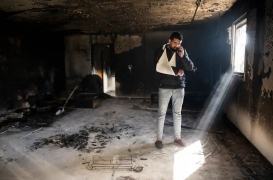 فلسطيني يقف وسط بقايا منزله الذي أحرقه المستوطنون في بلدة حوارة قرب نابلس
