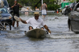 خوان كارلوس سانشيز يجدف بالقارب بحذائه في شارع غمرته المياه في ميامي بيتش في العام الماضي.