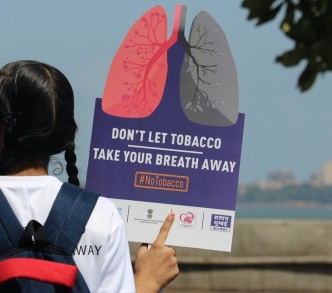 فتاة تحمل لافتة في مسيرة للتوعية بأضرار التبغ