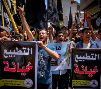 فلسطينيون يحملون ملصقات مكتوب عليها "التطبيع خيانة" في مظاهرة بمدينة غزة ضد الاتفاقية بين "إسرائيل" والإمارات بوساطة أمريكية