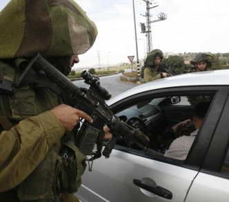 جندي إسرائيلي يصوب سلاحه على سائق فلسطيني عند حاجز تفتيشي خارج الخليل