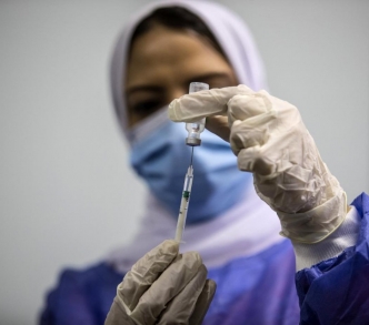 إحدى العاملات في مجال الصحة تجهز جرعة من لقاح أوكسفورد "إسترازينيكا" في 4 مارس/ آذار أول يوم للتطعيم العام في مصر.
