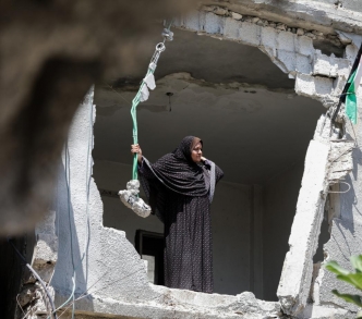 امرأة تنتظر الحصول على تمويل لإعادة بناء منزلها، الذي يعد واحدا من بين حوالي 18 ألف منزل تضرر أو دُمر أثناء الاشتباكات في غزة في أيار/ مايو 2021. 