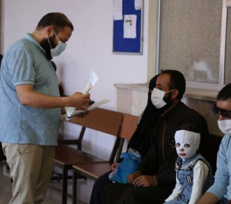 سوريون ينتظرون في مكتب التنسيقات الطبية عند معبر باب الهوى على الحدود مع تركيا