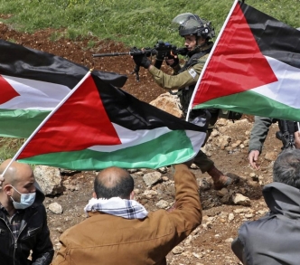 فلسطينيون يتظاهرون قرب نابلس بينما يوجه الجندي الإسرائيلي بندقيته نحوهم