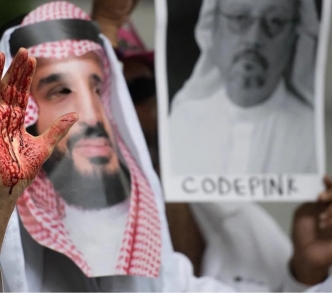 متظاهر يرتدي قناعًا كأنه ابن سلمان ويده مخضبة بالدماء أمام السفارة السعودية في واشنطن 2018