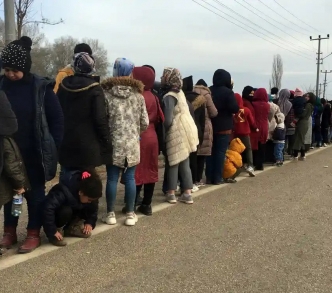 اللاجئون يصطفون للحصول على مساعدات غذائية عند معبر بازاركولي على الحدود التركية اليونانية