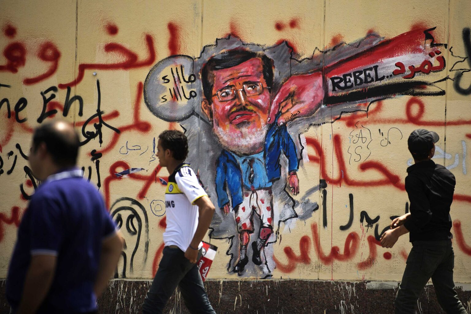 egyptians-walk-past-anti-morsi-graffiti-data