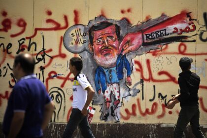 egyptians-walk-past-anti-morsi-graffiti-data