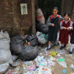 Egyptian-schoolgirls-walk-past-trash-bags-and-litter-in-the-impoverished-Al-Zabbalin-area-in-Al-Mukatam-neighborhood-in-Cairo-on-April-202010photoKhaled-DesoukiAFPGetty-Images