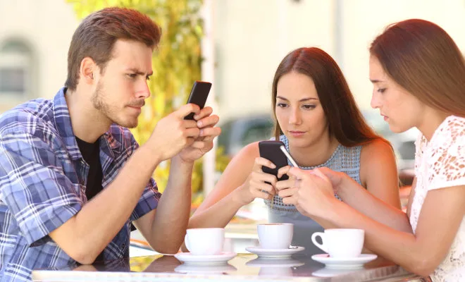 stock-photo-group-of-three-smart-phone-addicted-friends-in-a-coffee-shop-terrace-everyone-with-one-cellphone-287385101