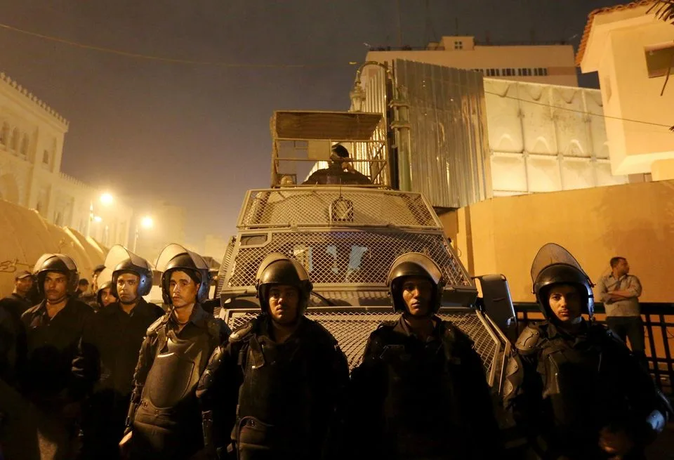 986918-riot-police-officers-stand-guard-in-front-of-the-cairo-security-directorate-in-egypt
