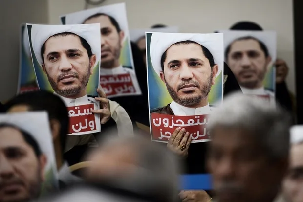 bahraini_men_hold_placards_bearing_the_portrait_of_sheikh_ali_salman_head_of_the_shiite_opposition_movement_al-wefaq_during_a_protest_on_may_29_2016_afp
