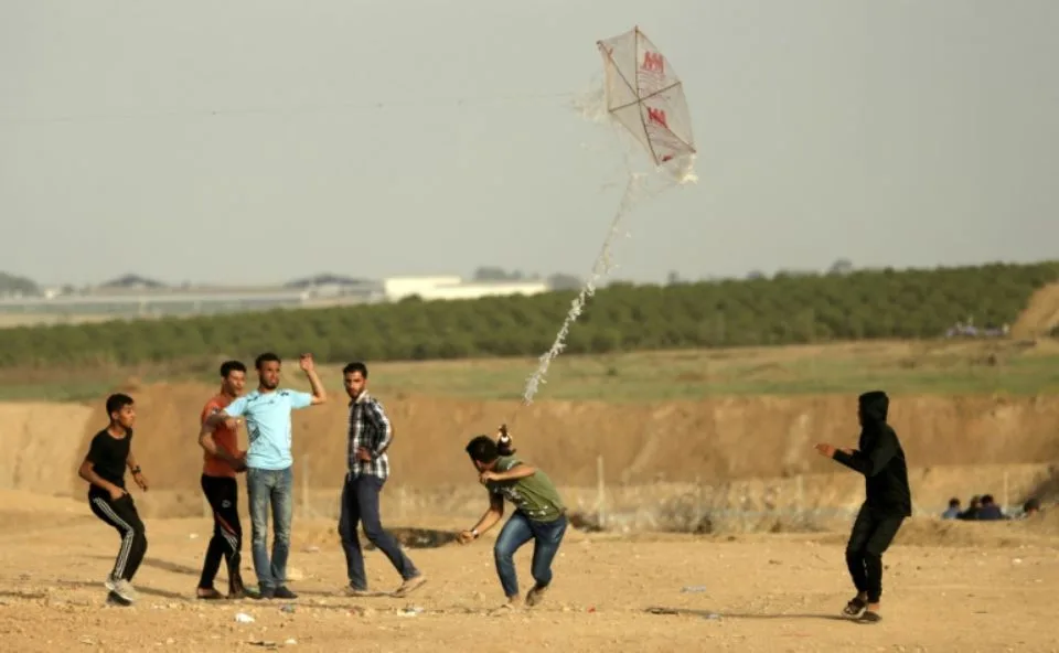 1115058-des-jeunes-palestiniens-tentent-de-faire-s-envoler-un-cerf-volant-auquel-est-attache-un-cocktail-mol