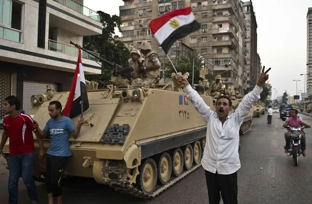 egyptians_salute_army_tanks_upon_their_deployment_on_a_street_leading_to_cairo_university_on_july_3_2013_afp_2