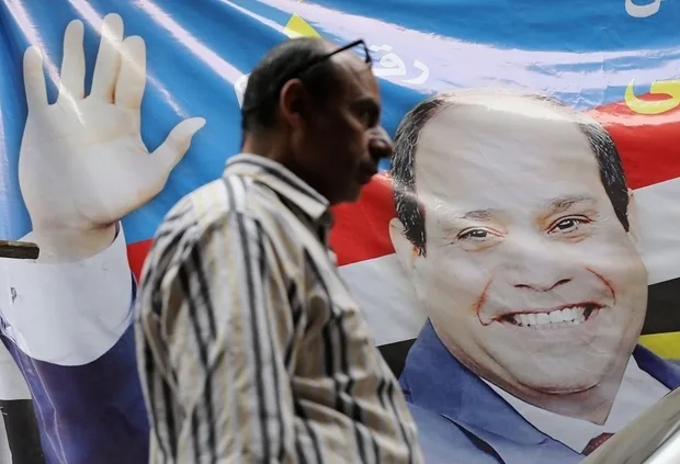 egyptian_man_walks_past_poster_of_abdel_fattah_al-sisi_reuters