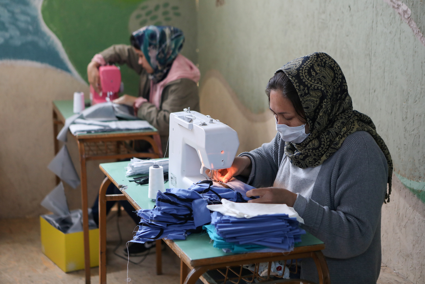 لاجئون من مخيم موريا يخيطون أقنعة واقية مصنوعة يدويًا بعد الإبلاغ عن حالة إصابة بفيروس كوفيد-19 في لسبوس
