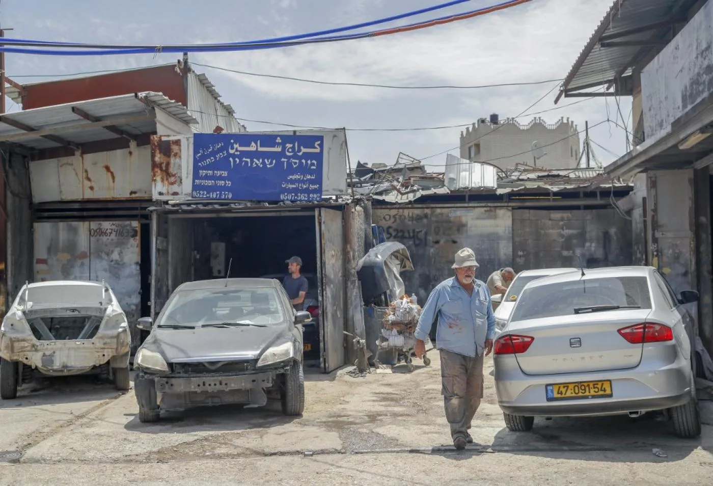 Palestinian auto body technician Khaled Shaheen (R) works at his shop in the neighbourhood of Wadi al-Joz in occupied east Jerusalem, on June 4, 2020