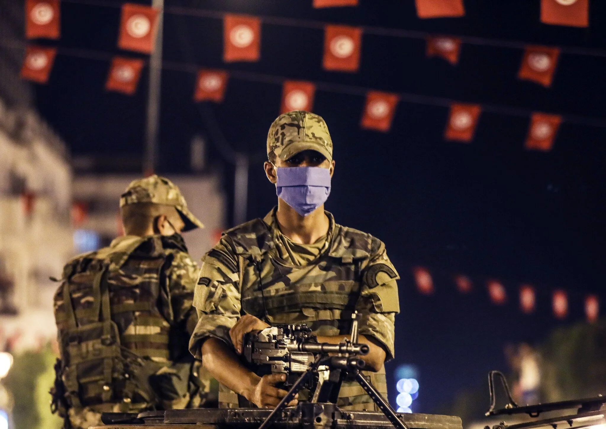 صورة لبعض الجنود يقفون بجانب بعضهم البعض في تونس العاصمة بعد أن أقال الرئيس التونسي قيس سعيد الحكومة وجمّد أعمال البرلمان هذا الأسبوع.
