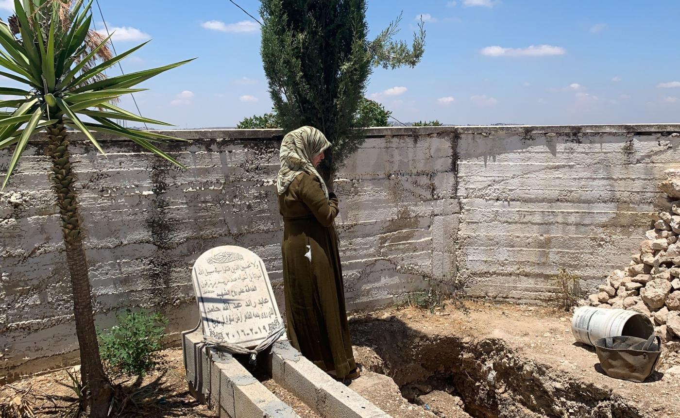 فاطمة حماد تصلي بجانب قبر محفور أُعدّ لدفن ابنها محمد في بلدة سلواد بالضفة الغربية المحتلة، وقد رفضت إسرائيل تسليم جثمانه.