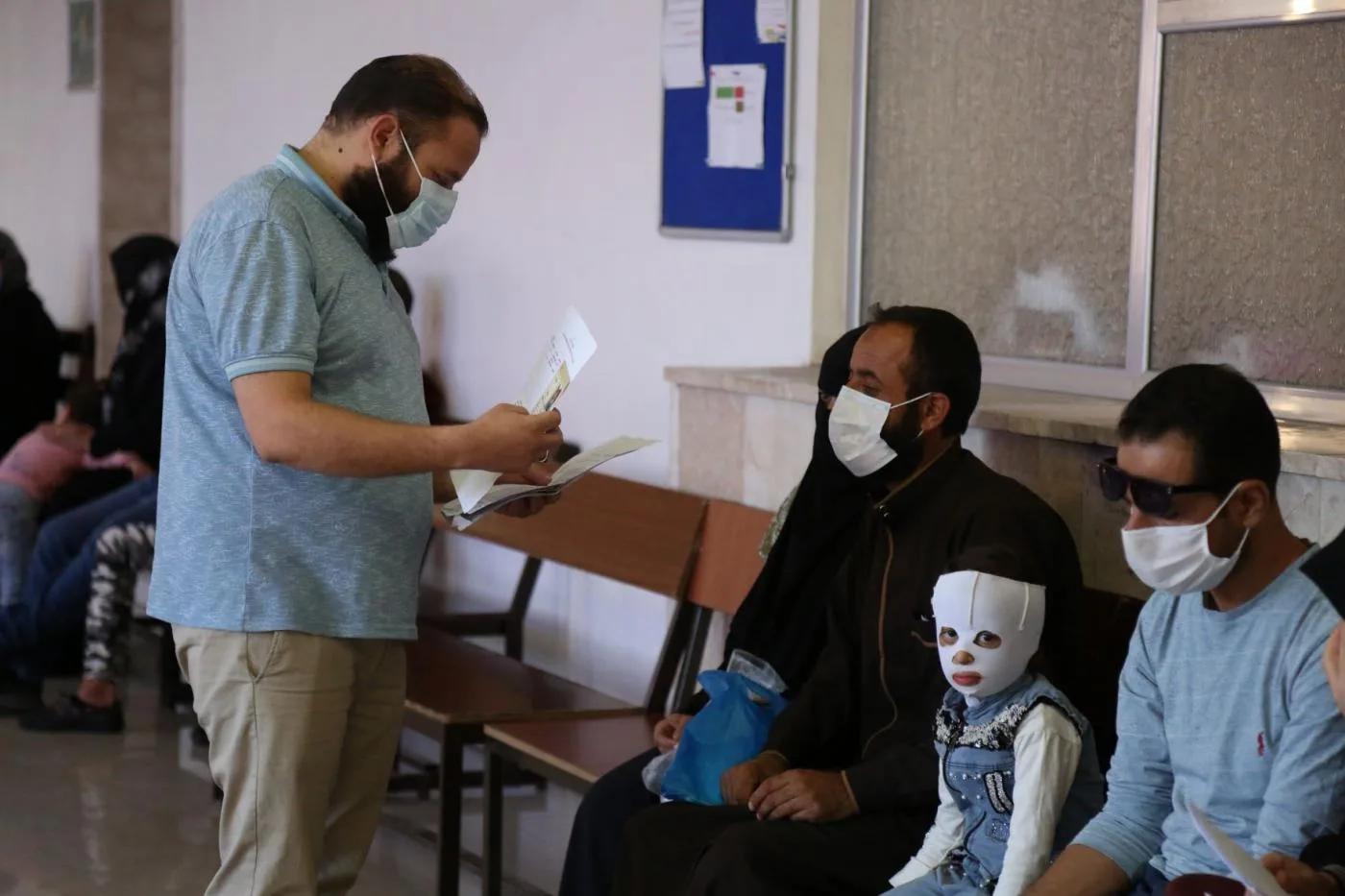 سوريون ينتظرون في مكتب التنسيقات الطبية عند معبر باب الهوى على الحدود مع تركيا