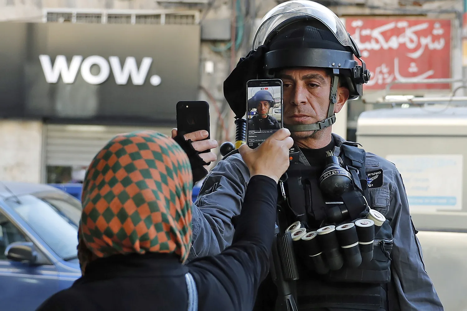 فلسطينية تلتقط صورة لأحد أفراد قوات الأمن الإسرائيلية الذي كان بصدد التقاط صورة لها دون إذن في أحد شوارع القدس، 16 كانون الأول/ ديسمبر 2017.