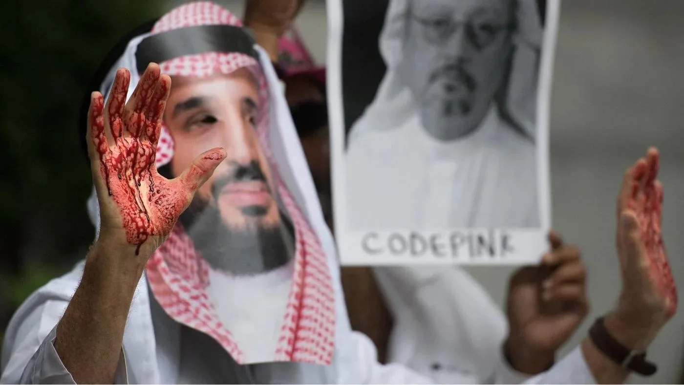 متظاهر يرتدي قناعًا كأنه ابن سلمان ويده مخضبة بالدماء أمام السفارة السعودية في واشنطن 2018