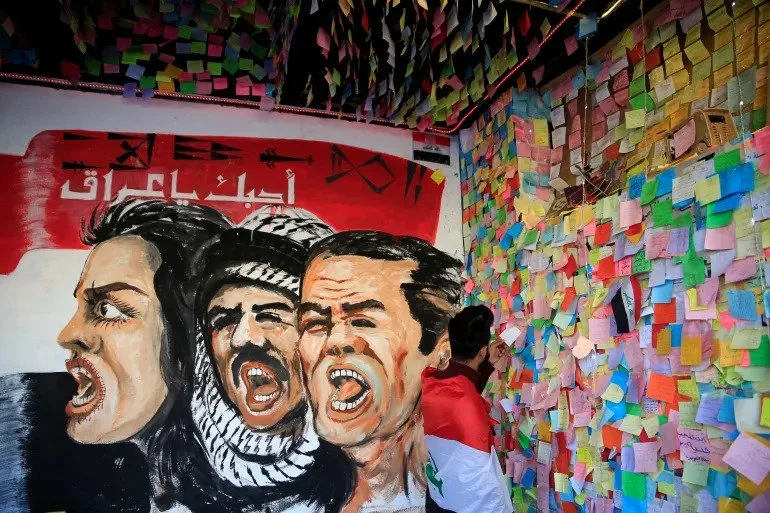 متظاهر عراقي يفف أمام حائط الأمنيات على جدران المطعم التركي في بغداد في أثناء المظاهرات المناهضة للحكومة